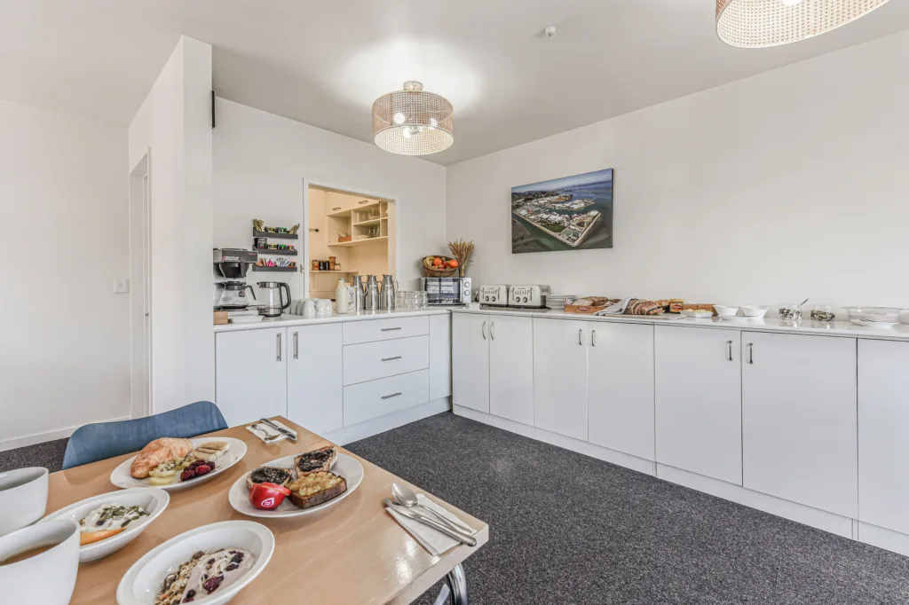 Breakfast room with continental buffet counter, coffee maker and a table set with locally sourced produce