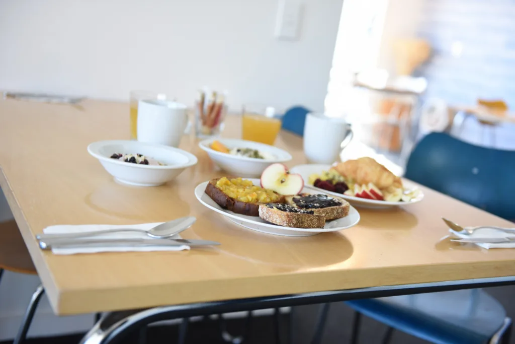 Breakfast table in morning light with toast, fruit and yoghurt