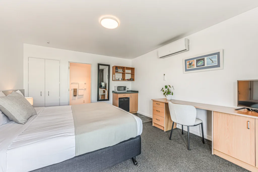 Courtyard Studio with king bed, desk, TV, microwave and fridge