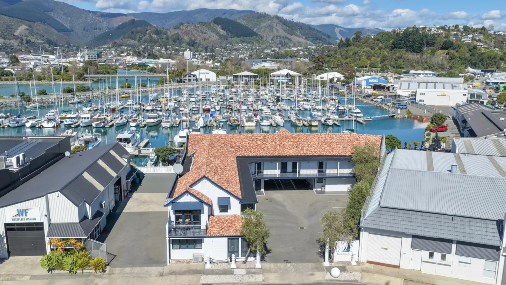 Aerial view of Harbourside Nelson and its courtyard, with Nelson Marina, the city and hills beyond