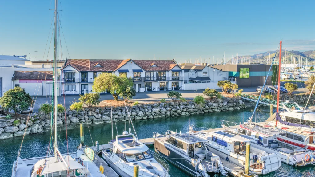 Harbourside Nelson seen across Nelson Marina, with moored launches in front