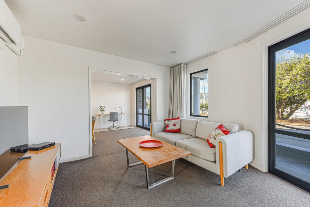 Marina Front Apartment lounge with sofa, coffee table and doors to the patio