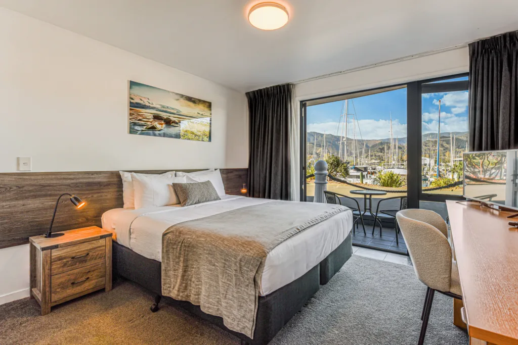 Marina Front Studio with super king bed and doors opening to a patio facing Nelson Marina