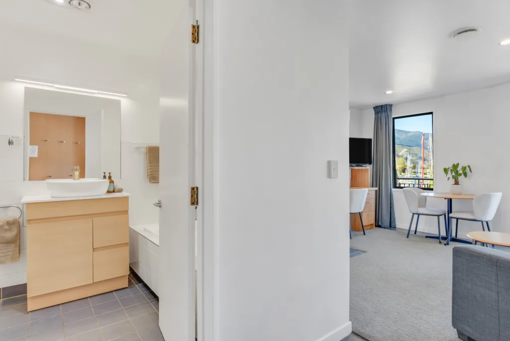 Marina View Apartment hallway with bathroom on one side and living area with marina view on the other