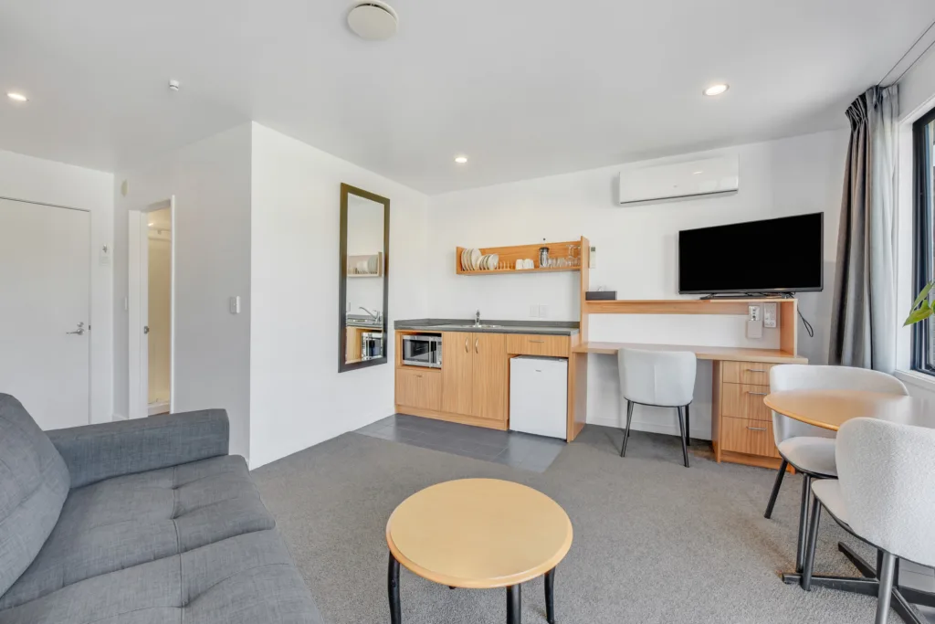 Marina View Apartment living area with sofa, kitchenette, desk and TV