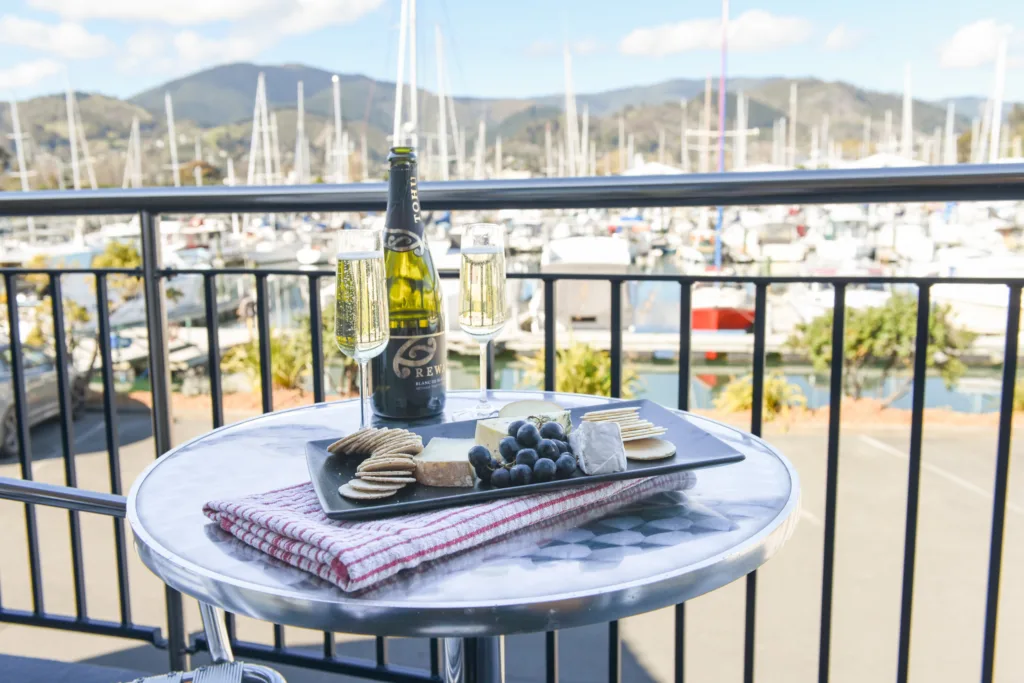 Tohu Rewa sparkling wine and a cheese platter on a balcony overlooking Nelson Marina