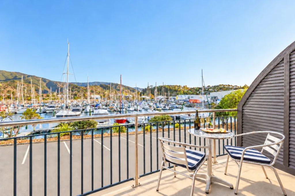 Sunny balcony with outdoor table overlooking Nelson Marina and the hills