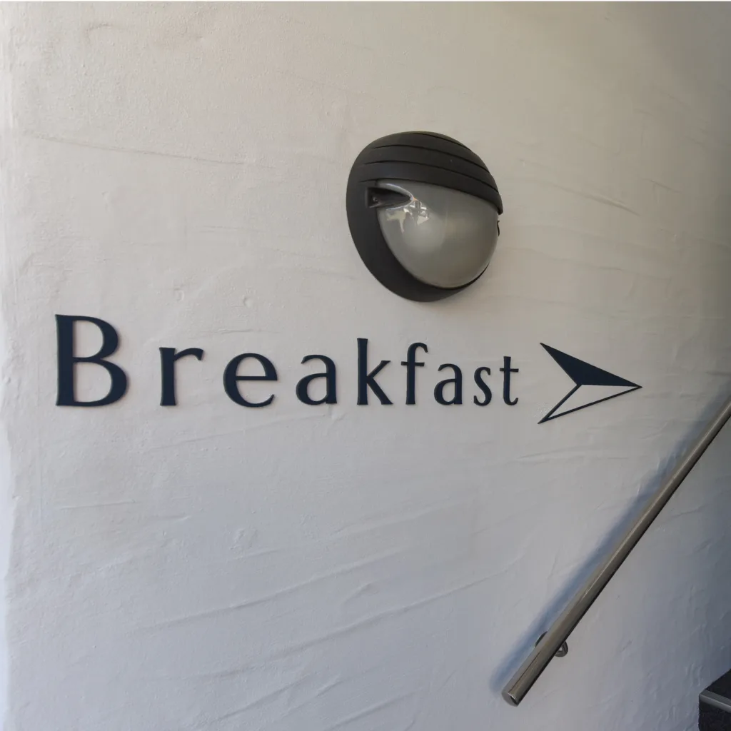 Breakfast sign and arrow beside the stairs