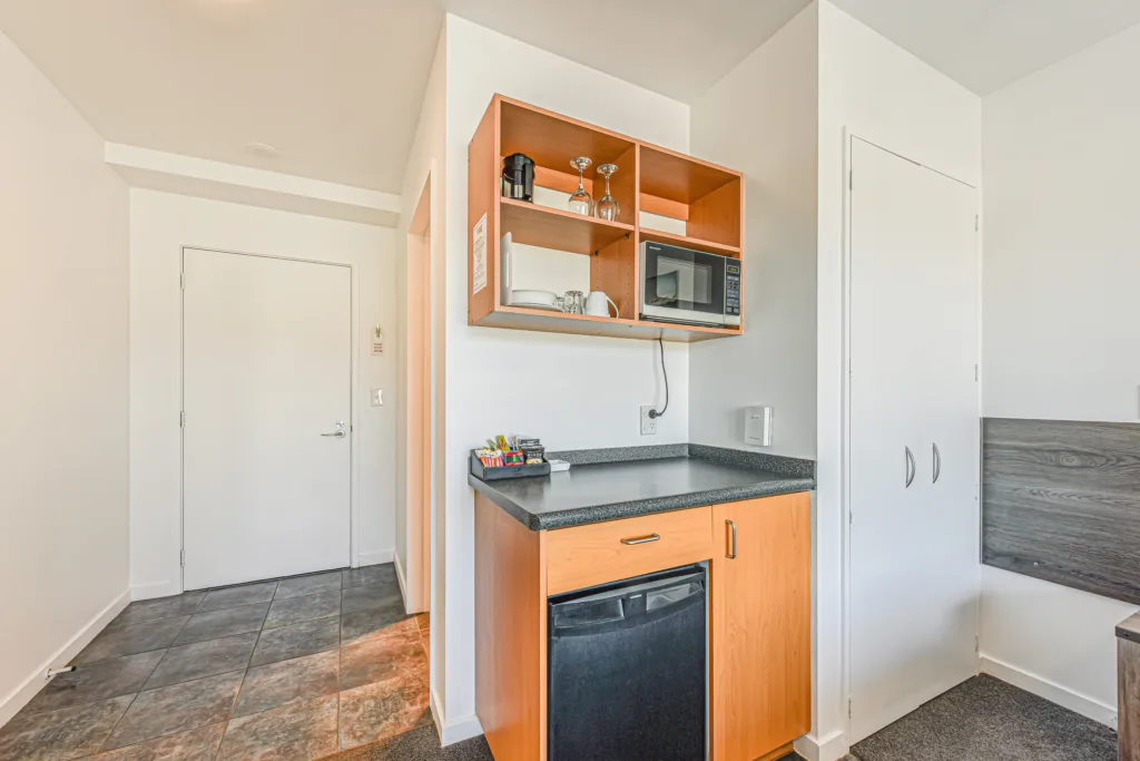 Kitchenette with microwave, bar fridge, glassware and tea and coffee
